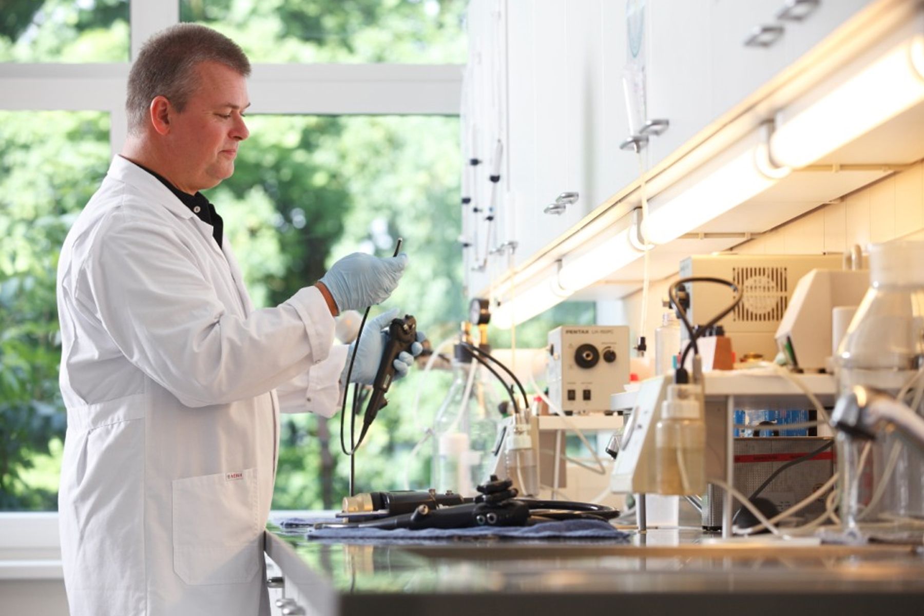 foto of a technician in a lab coat checking an endoscope