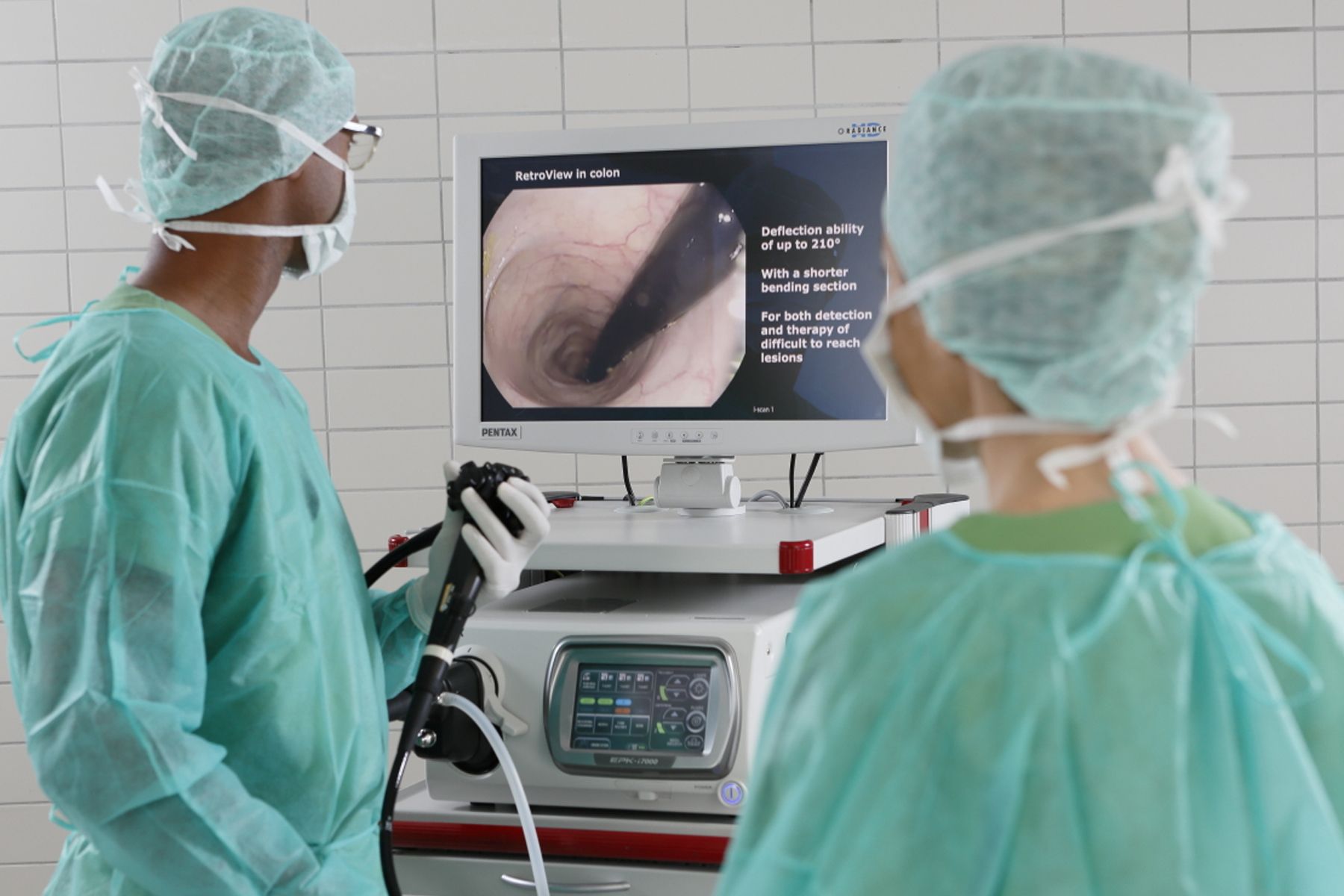 Two physicians in scrub suits examining a computer screen displaying a retroview in the colon