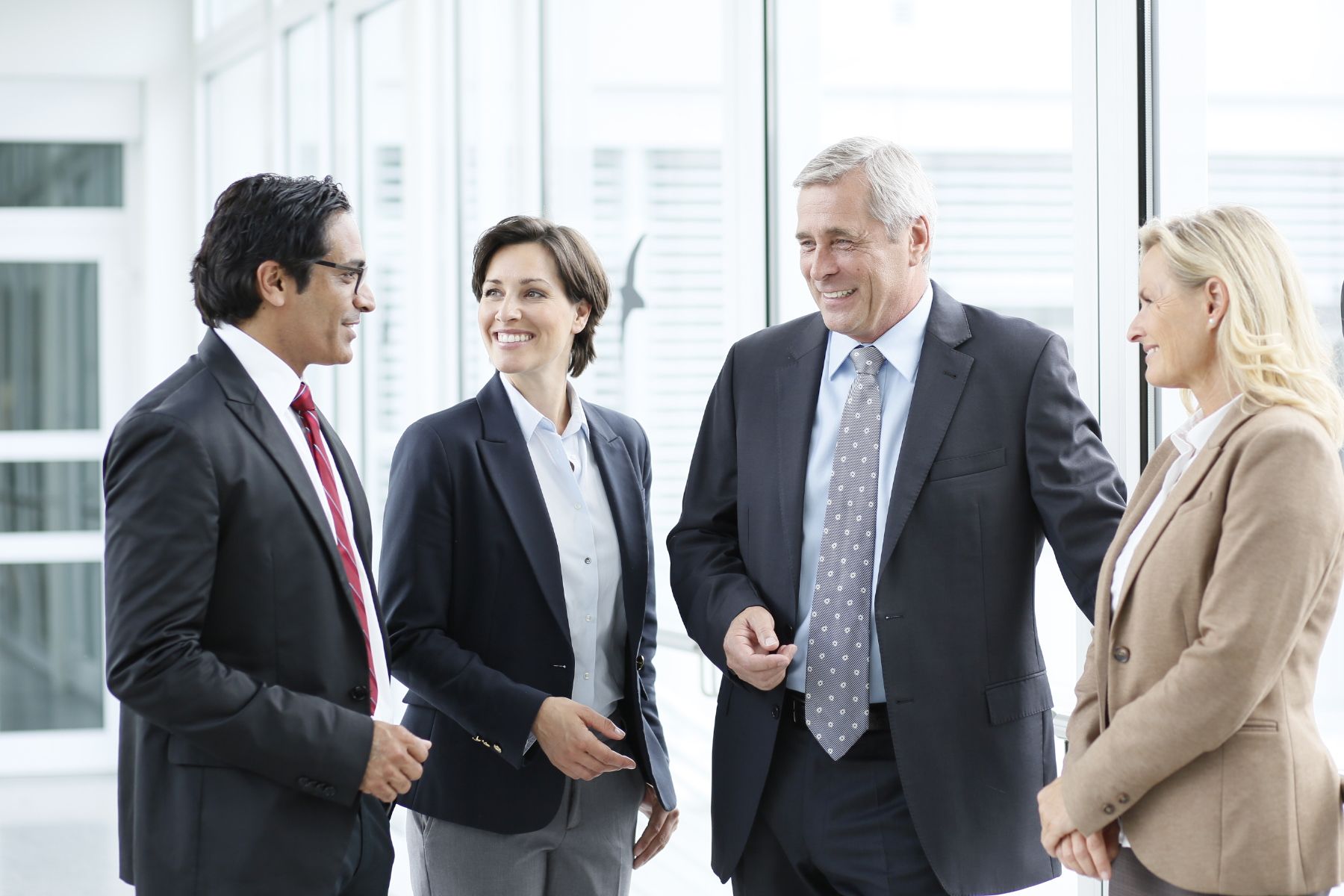 foto of four professionals standing next to each other and talking