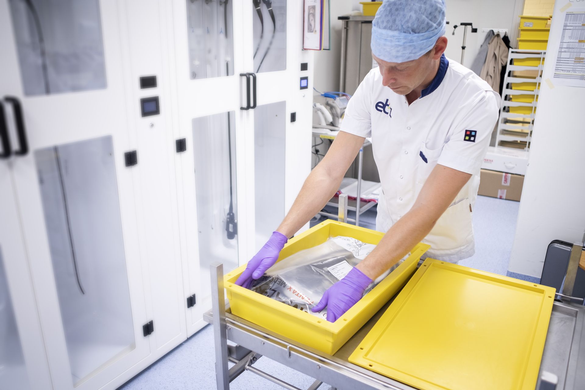 A man packs an endoscope into a sterile bag